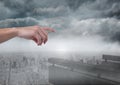 Hand pointing in cloudy sky over city Royalty Free Stock Photo