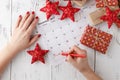 Hand pointing December 25 in a calendar surrounded by Christmas ornaments Royalty Free Stock Photo