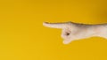 Hand is pointing finger and wear medical glove on yellow background. Studio shooting Royalty Free Stock Photo