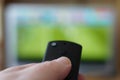 hand pointing remote control at tv with soccer or football match Royalty Free Stock Photo