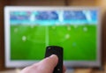 hand pointing remote control at tv with soccer or football match Royalty Free Stock Photo