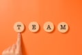 Hand pointing team word written on wooden blocks with abstract background, Business and teamwork concept, Unity of Royalty Free Stock Photo
