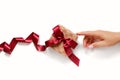 Hand pointing to gift box with dark red satin ribbon Royalty Free Stock Photo