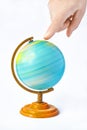 Hand pointing to a rotating globe