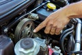 a hand pointing to a serpentine belt in an engine compartment Royalty Free Stock Photo