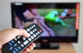 Hand pointing a tv remote control towards the tele Royalty Free Stock Photo