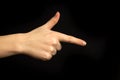 Hand points to something. Woman hand gesture, pointing sign, gesture look at this, pay attention. Black background photo