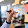 Pen poised to annotate orange line graph in organized workspace environment