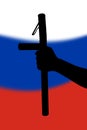 hand with police tonfa rubber stick silhouette and blurry russian flag in the background