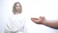 Hand of poor man praying to God, asking for wealth, Jesus standing in light Royalty Free Stock Photo