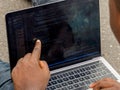 Hand portrait of african web developer pointing finger at line of computer code