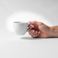 The hand is positioned from the side gripping the handle of the mug with the Royalty Free Stock Photo