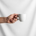 The hand is positioned to the left gripping the mug by its handle Royalty Free Stock Photo