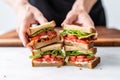 hand positioning the second toast piece on the blt sandwich Royalty Free Stock Photo