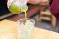 Hand pour green tea from bottle to plastic glass