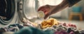 The hand pouring detergent into a washing machine full of colorful clothes. AI generated image Royalty Free Stock Photo