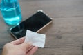 Hand pouring ethyl alcohol from bottle into a cotton piece for clean mobile phone, corona virus or Covid-19 protection