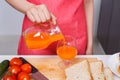 Hand pouring a fresh orange juice in a glass Royalty Free Stock Photo