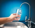 Hand pouring a glass of water from filter tap