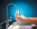 Hand pouring a glass of water from filter tap Royalty Free Stock Photo