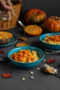 Hand pouring honey over bowl of millet porridge with pumpkin Royalty Free Stock Photo