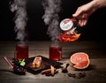 Hand pouring hot tea from glass kettle. Steaming tea in glasses. Delicious Japanese sweet dessert on dark background. Royalty Free Stock Photo