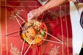 Hand pouring ingredients onto a serving of yusheng or yee sang with raw salmon belly during Chinese New Year for good Royalty Free Stock Photo