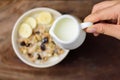 Hand pouring milk into a bowl of muesli with cereal Royalty Free Stock Photo