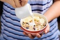 Hand pouring milk into a bowl of muesli with cereal Royalty Free Stock Photo
