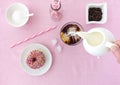 Hand pouring Milk into Cold Brew Coffee and Donut on Pink