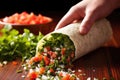 hand pouring pico de gallo onto a burrito