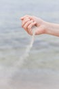 Hand pouring sand