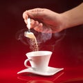 Hand pouring sugar in coffee cup