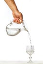 Hand pouring water from glass jug to glass Royalty Free Stock Photo