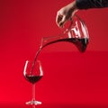 Hand pouring wine in glass from decater Royalty Free Stock Photo