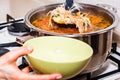 Hand pours borscht or red vegetable soup in bowl Royalty Free Stock Photo