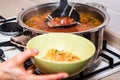 Hand pours borscht or red vegetable soup in bowl Royalty Free Stock Photo