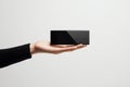 Hand presenting a black rectangular electronic device isolated on white background Royalty Free Stock Photo