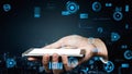 Hand Holding Smartphone with Futuristic Digital Interface Display and Data Visualization in a Modern City Background Royalty Free Stock Photo