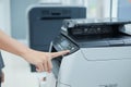 Hand press button on panel of printer scanner or laser copy machine in office Royalty Free Stock Photo