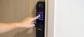 Hand press PIN number for smart digital door lock while open or close the door at home or apartment. NFC Technology, Fingerprint