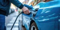 Hand Presses Button At Ev Charging Station, Powering Up Blue, Ecofriendly Car Royalty Free Stock Photo