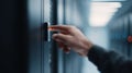 A hand presses a button on server rack equipment in a dark server room, abstractly representing data access, network security, and Royalty Free Stock Photo