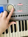 Hand presses a large button to play the synthesizer