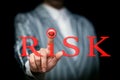 Hand presses the red button in the word risk, risk management concept, loss insurance, risk hedging