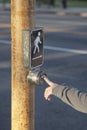 Hand pressing the button on pedestrian crossing Royalty Free Stock Photo