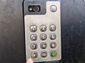 Hand pressing code on intercom keypad at building entrance for secure access to residential area Royalty Free Stock Photo