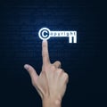 Hand pressing copyright key icon over computer binary code blue Royalty Free Stock Photo