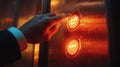 A hand pressing the elevator button in a modern building during evening hours Royalty Free Stock Photo