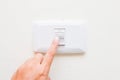 Hand pressing light power switch on wall Royalty Free Stock Photo